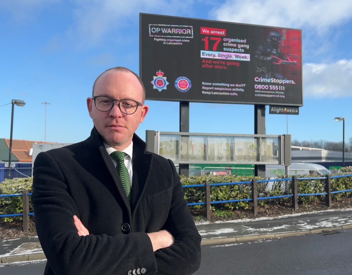 Commissioner Andrew Snowden in front of Op Warrior campaign billboard